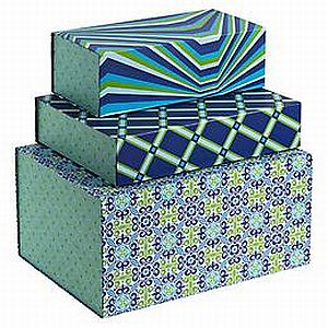 Three colorful, patterned boxes stacked; top box has blue and green stripes, middle box has a blue and green plaid pattern, and bottom box has a blue floral print.