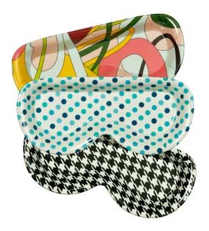 Colorful eyeglass cases in various patterns: multi-colored abstract, blue polka dots, and black houndstooth.