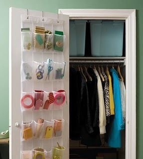 Shoe organizer hanging on door, used to store various office supplies like tape, scissors, and sticky notes.