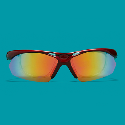 Red sports sunglasses with reflective orange-tinted lenses on a turquoise background.