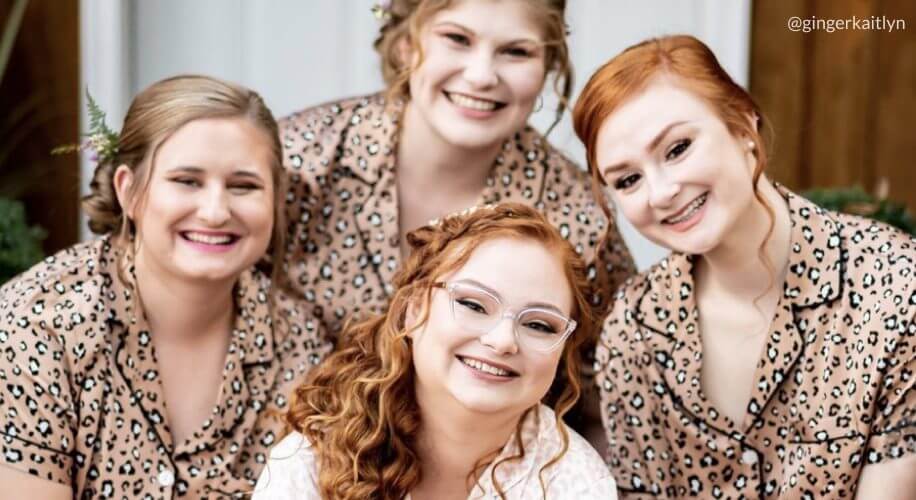 Four women wearing matching leopard print pajamas, smiling close together. Text: @gingerkaitlyn