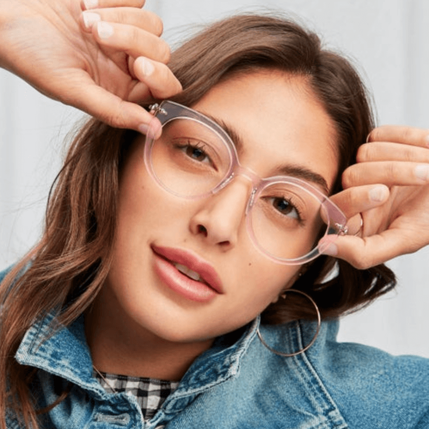 Woman wearing clear-framed eyeglasses with oversized round lenses.