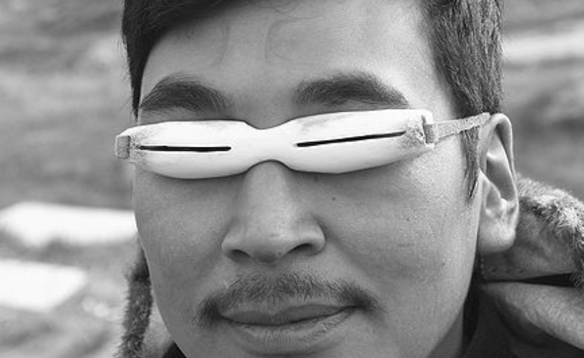 Person wearing traditional snow goggles with narrow slits for eye protection.