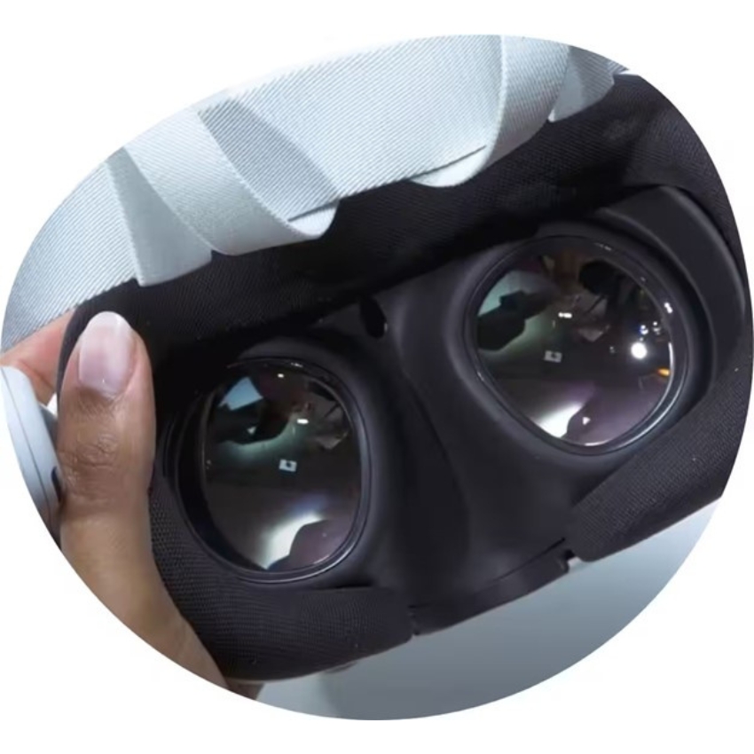 A virtual reality headset held by hand, showing its black foam interior and two reflective lenses.