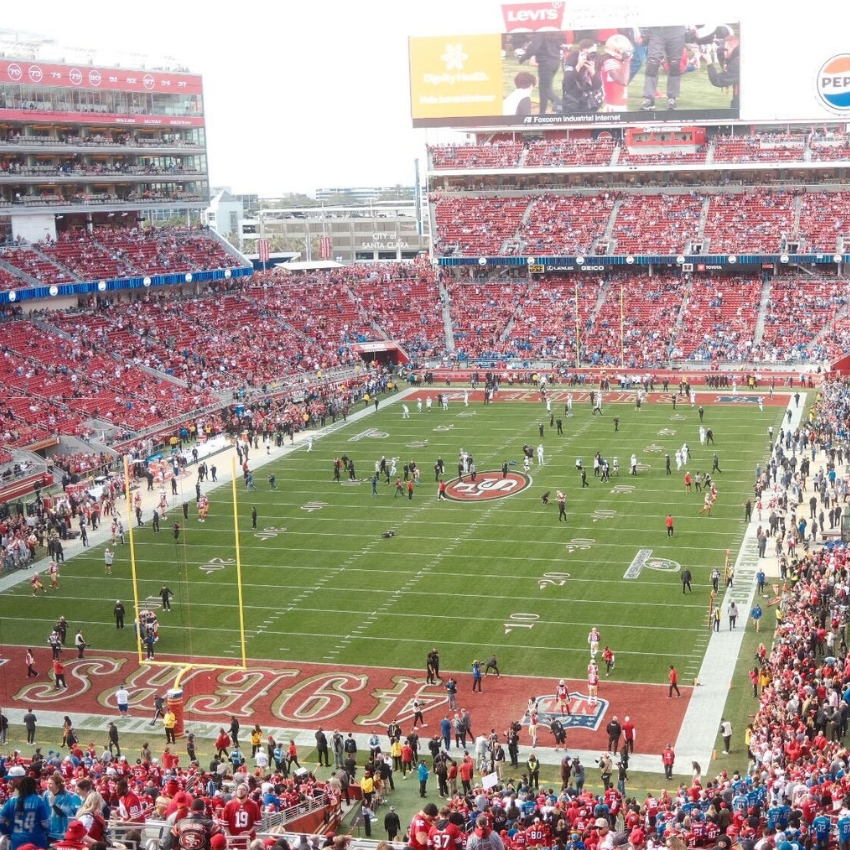 49ers football field with players warming up. Scoreboard displays "Flying Health, Hello Future!" and "Levi's."