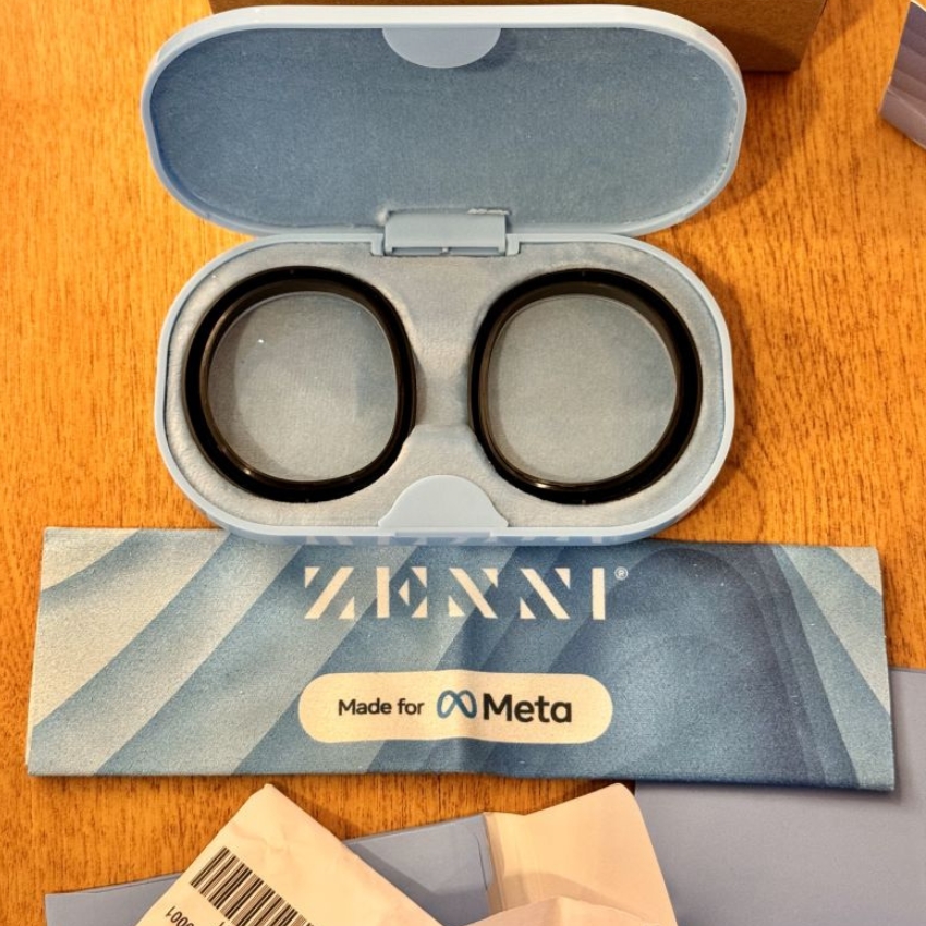 Open case with two round lenses. Cloth reads: ZENNI, Made for Meta.