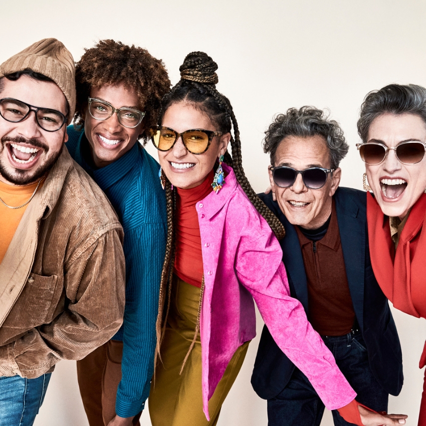 Group of five people wearing stylish eyewear, including glasses and sunglasses, smiling energetically.