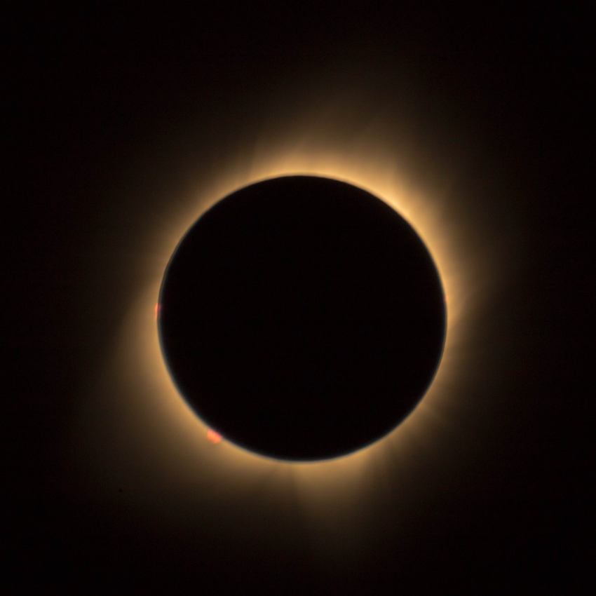 Solar eclipse with a glowing corona surrounding the darkened moon.