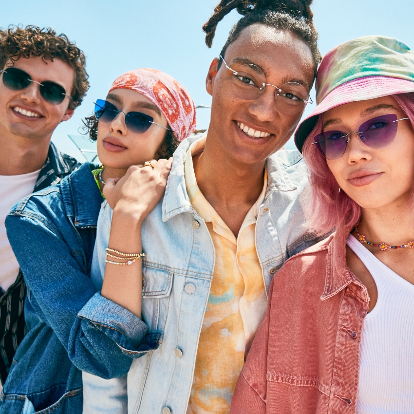 Four young people wearing stylish sunglasses, posing together in casual attire.