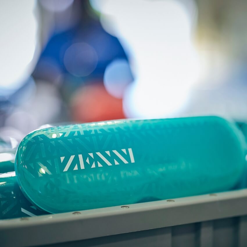 Teal capsule with "ZANNI" text and geometric pattern on its surface.