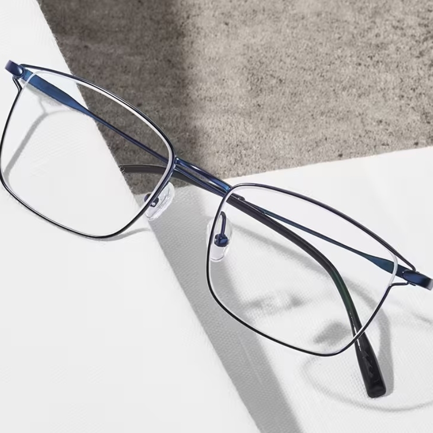 Thin metal-frame eyeglasses with a dark blue bridge and temples, featuring clear nose pads.