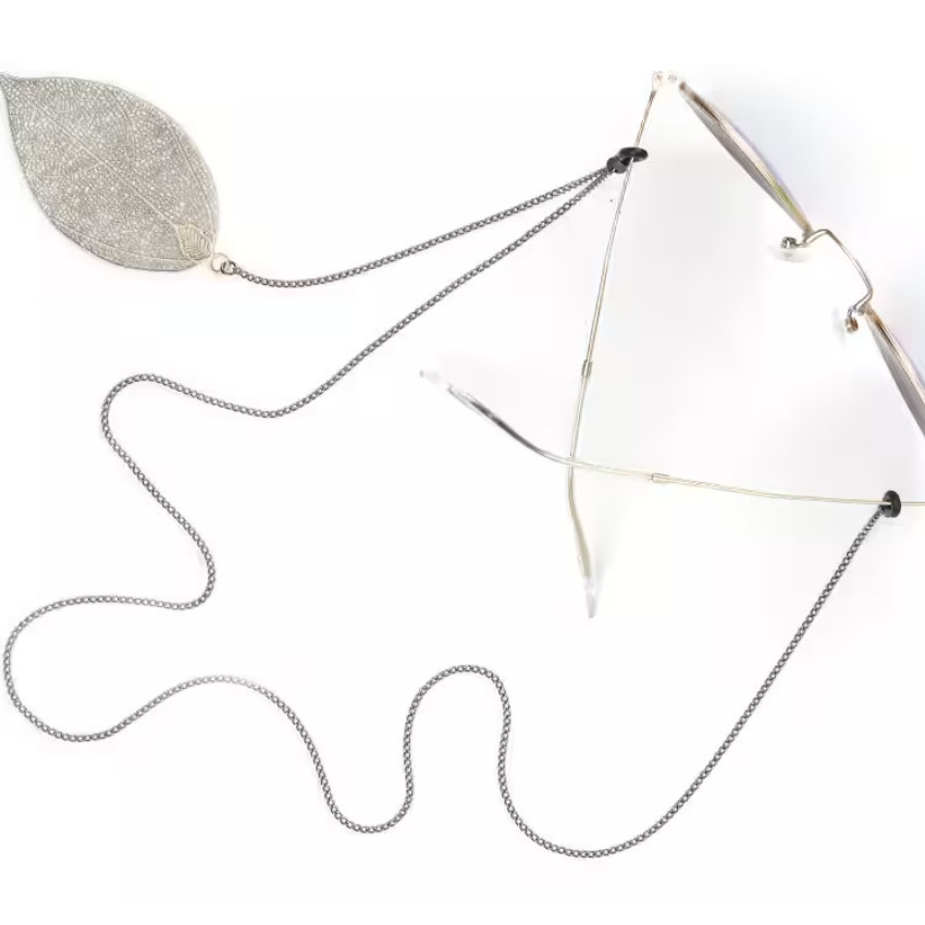 Thin-framed eyeglasses with an intricate metal leaf-shaped decorative chain holder.