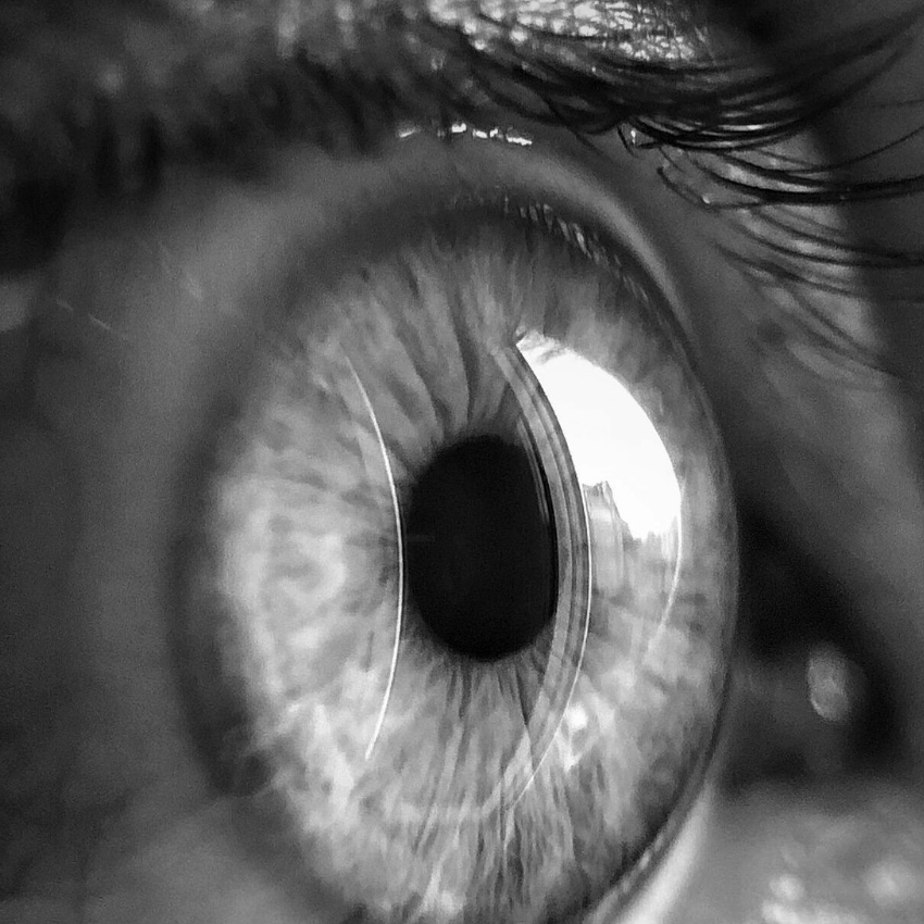 Extreme close-up of a human eye showing detailed iris patterns and eyelashes.