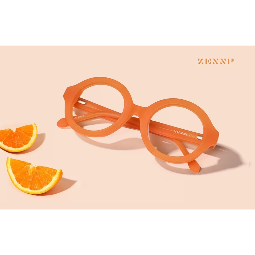 Orange round eyeglasses by Zenni, placed near orange slices; Zenni logo in the top right corner.