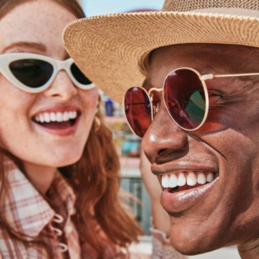 Two people wearing stylish sunglasses and smiling.