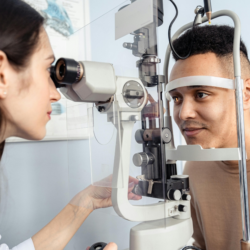 Optometrist using a slit lamp biomicroscope to examine a patient's eyes.