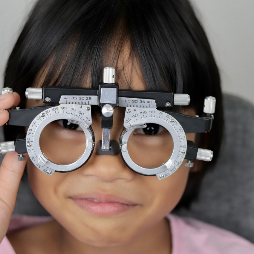 Child wearing adjustable optometry trial lens frame.