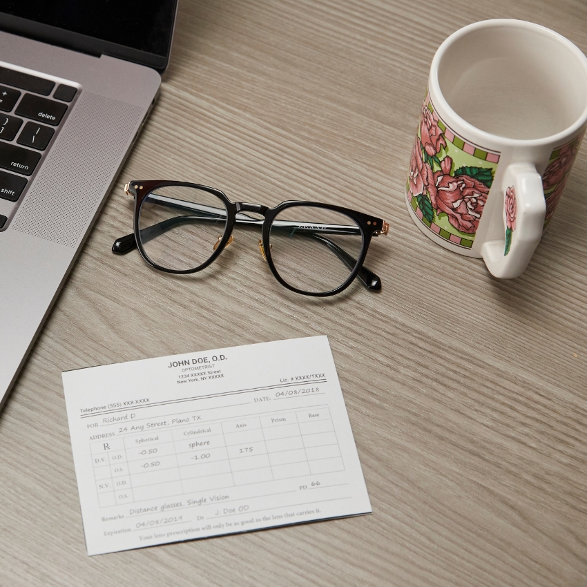 Eyeglasses next to a prescription labeled "JOHN DOE, O.D." with detailed prescription information.