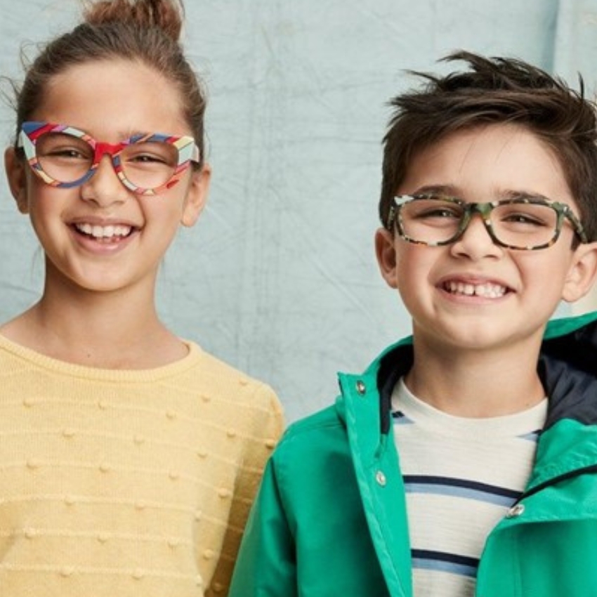 Kids wearing colorful eyeglasses. Left: Red and multicolor frames. Right: Green camo-style frames.