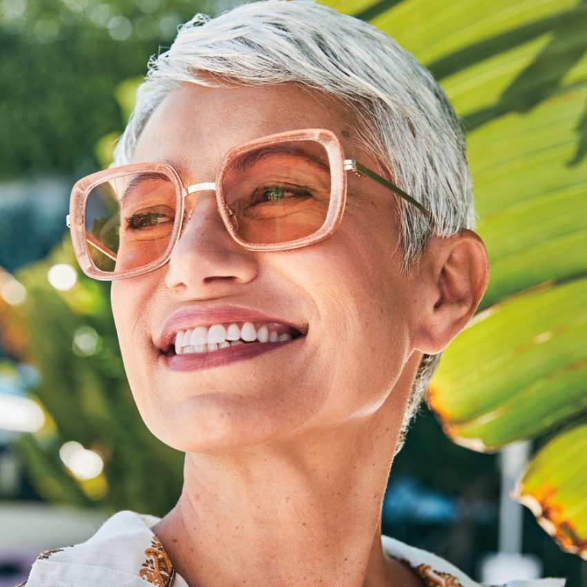 Woman wearing oversized, square-frame, pink sunglasses.