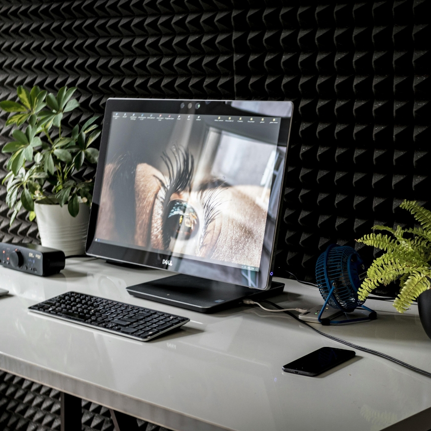 Dell desktop computer with a keyboard and mouse on a white desk. Screen displays a close-up image of an eye.