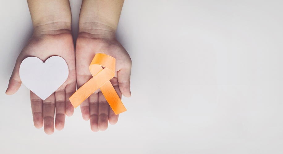 Person holding heart and orange ribbon
