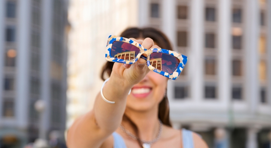 Girl holding sunglasses in the city