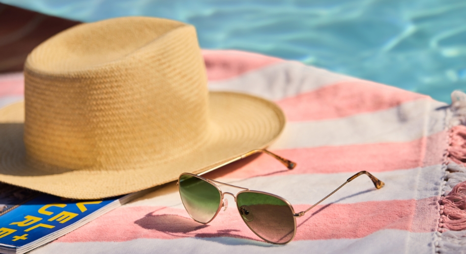 Sunglasses on beach towel next to pool
