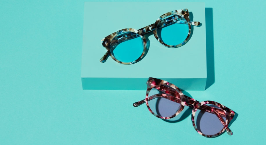Tortoiseshell sunglasses with tinted lenses against a blue background