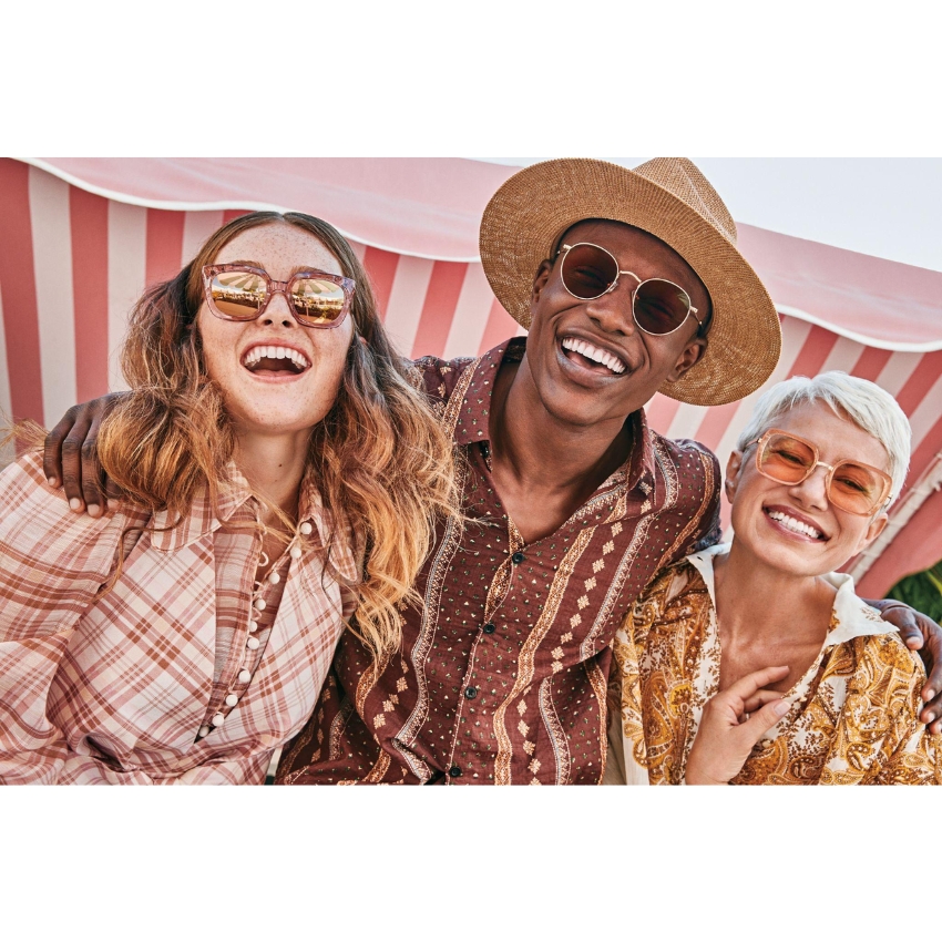 Three people wearing stylish sunglasses and patterned clothing, smiling and having fun together.