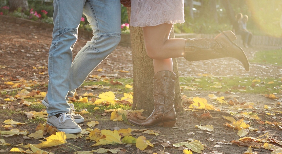 Two people holding hands with woman wearing cowboy boots