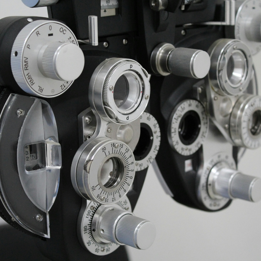 Optometry phoropter with various dials and lenses for vision testing.