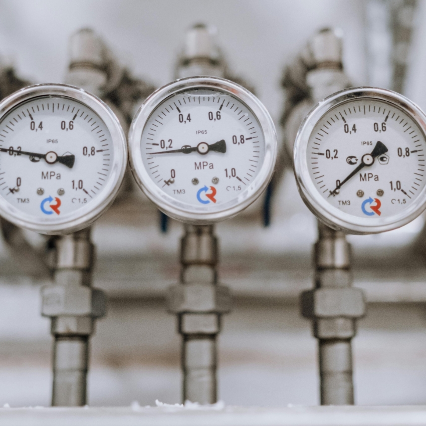 Three industrial pressure gauges showing readings in MPa. The gauges have the markings IP65, TM3, and C1.5 and a logo with red and blue curved arrows.