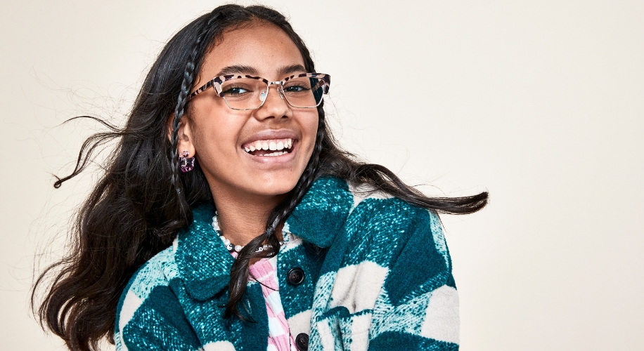 Person wearing rectangular tortoiseshell glasses and a green and white checkered jacket.