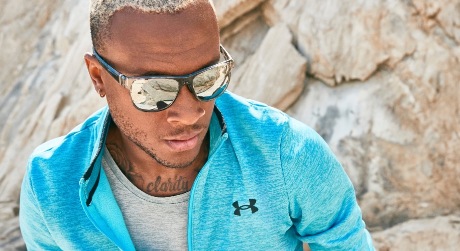 Man in Under Armour blue jacket wearing reflective sports sunglasses.