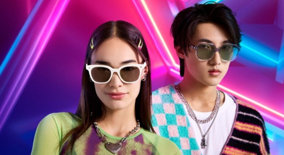 Two models wearing stylish sunglasses; the woman has white frames, the man wears round green shades.