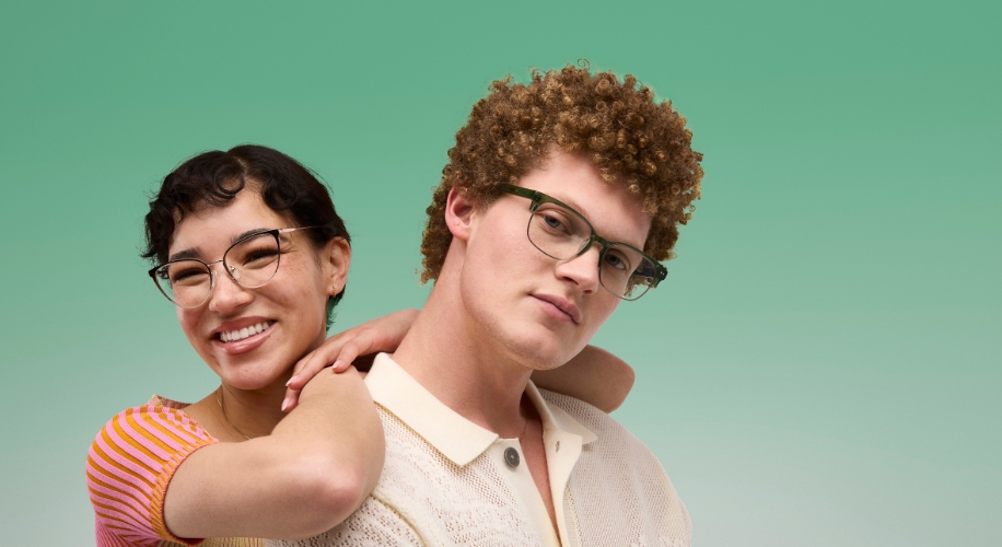 Two people wearing stylish eyeglasses, one in clear frames and the other in dark green frames.