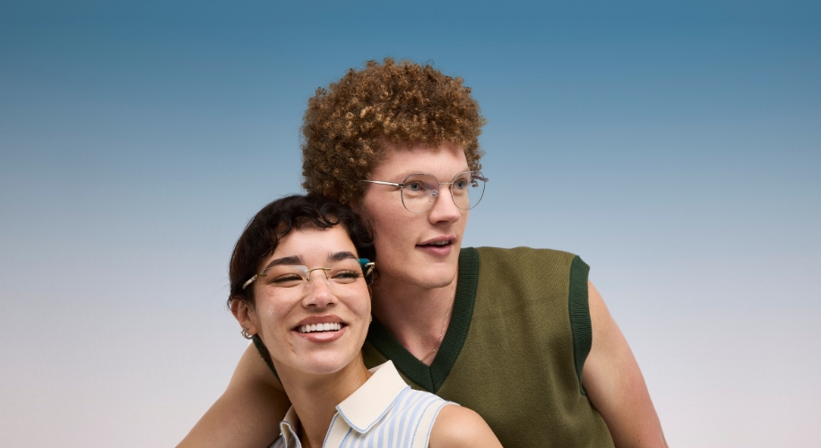 Two smiling models wearing stylish eyeglasses; one with short hair and one with curly hair.