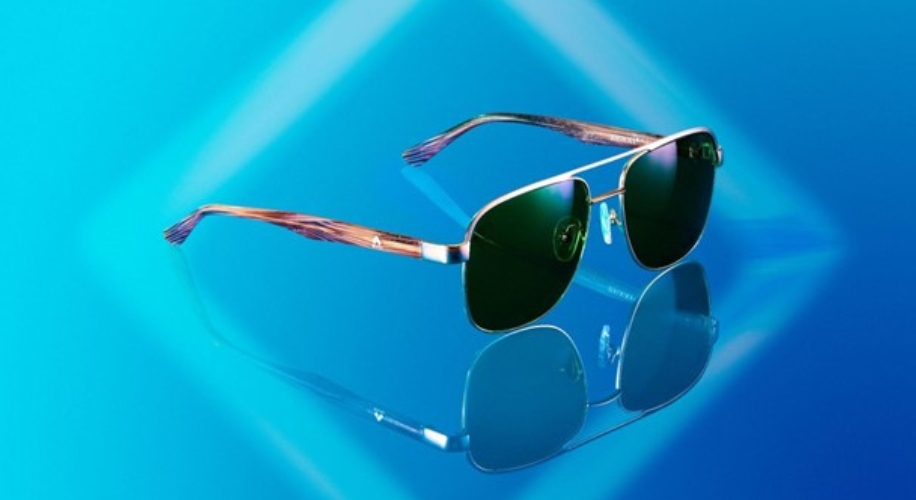 Aviator sunglasses with dark lenses and brown temples on a gradient blue background with reflection.