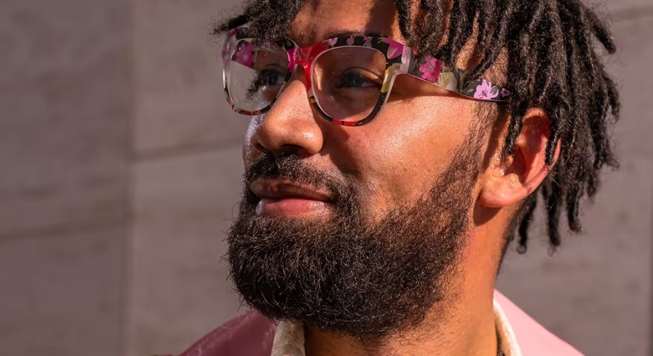 Man with floral-patterned eyeglasses and a bearded face.