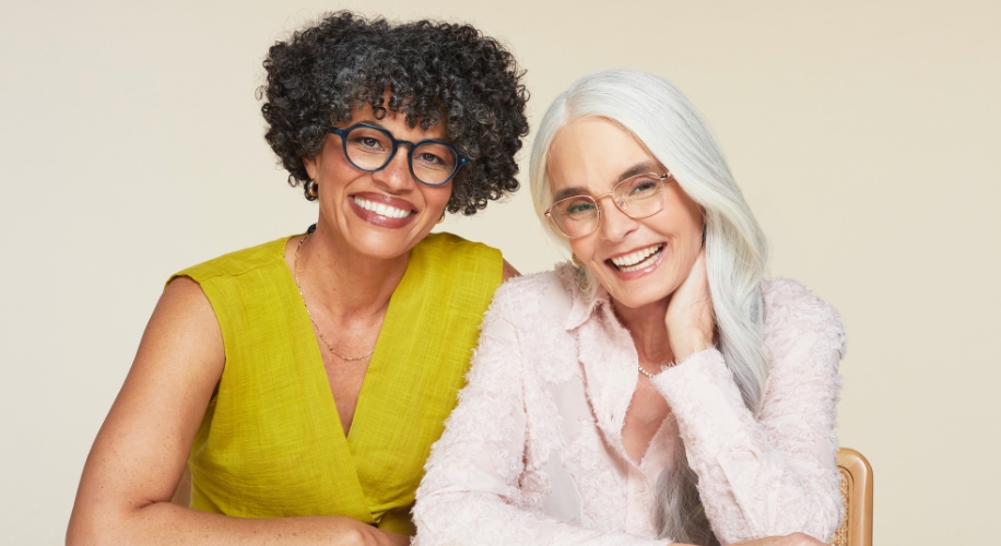 Two women smiling and wearing stylish eyeglasses.