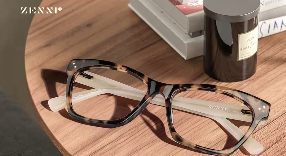 Zenni tortoiseshell eyeglasses on a wooden table. Text on lens: &quot;Made in China - 4452939&quot;.