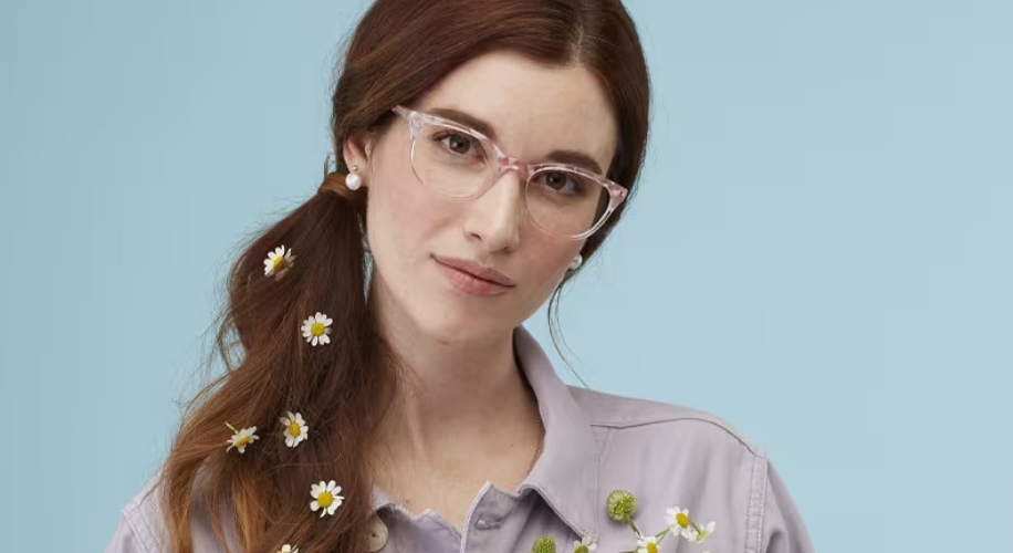 Clear-framed eyeglasses worn by a person with daisies in their hair.