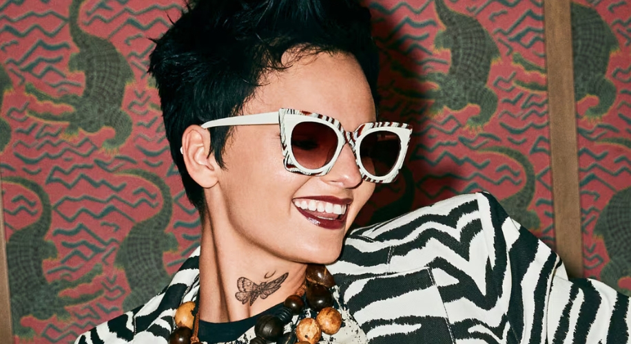 Person wearing black and white zebra-patterned sunglasses and matching zebra-print jacket.