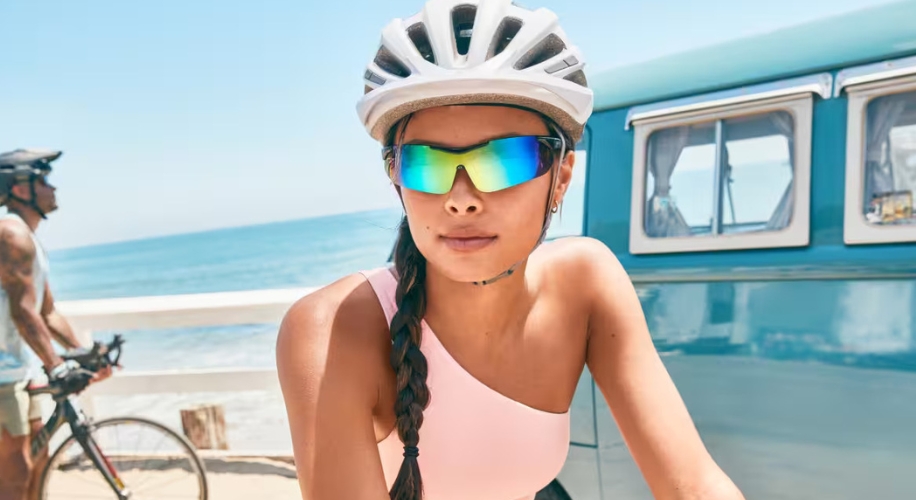 Person wearing reflective cycling sunglasses and a white helmet.