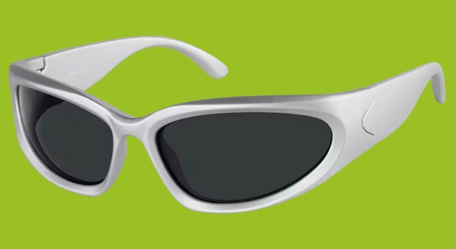 Silver sunglasses with black lenses on a green background.