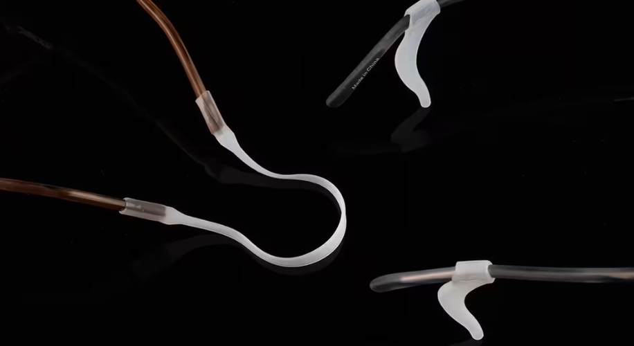 Clear eyeglass retainers with flexible ear hooks, shown on a black background.