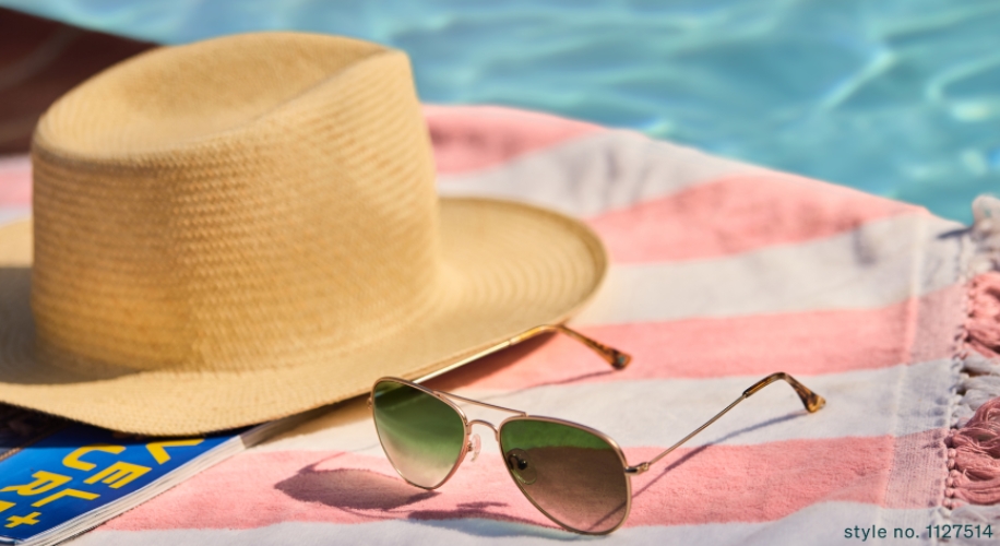 Straw hat and aviator sunglasses with green lenses on a pink and white striped towel. Style no. 1127514.