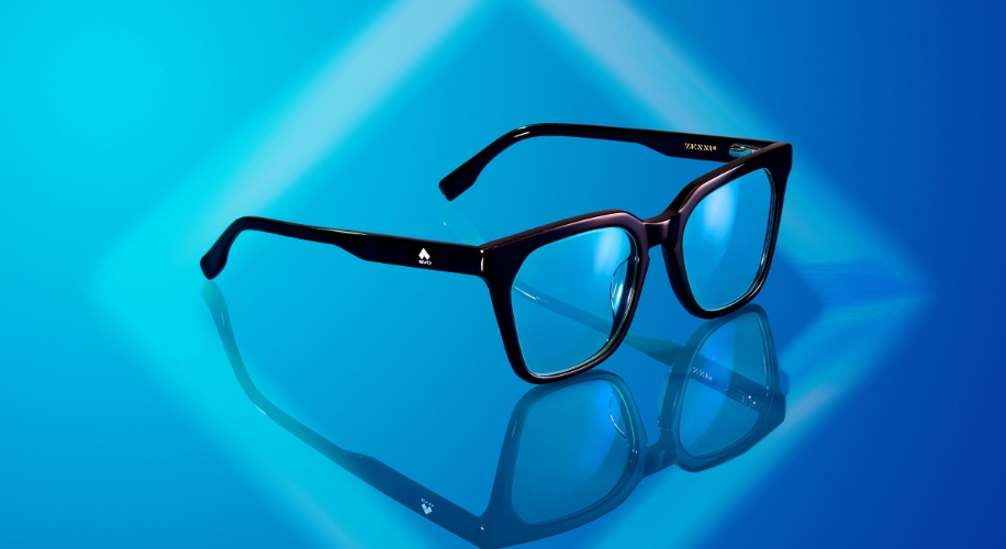 Black-rimmed eyeglasses with clear lenses, reflected on a blue surface; text on frame reads &quot;VENRON.&quot;