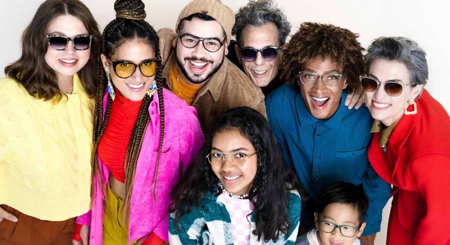 Group of eight people with diverse sunglasses and eyeglasses, smiling and showcasing unique eyewear styles.